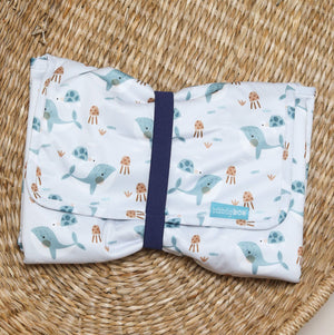 Folded changing mat with whale pattern on a woven mat