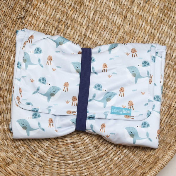Folded changing mat with whale pattern on a woven mat