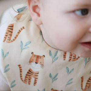 Baby wearing a bib with tiger pattern