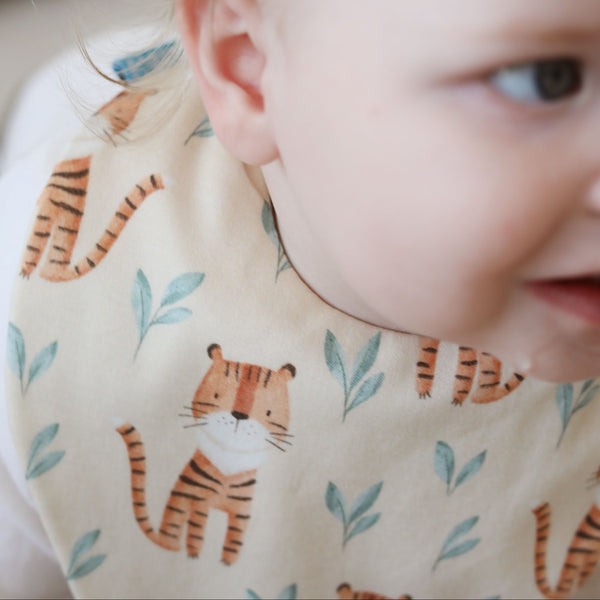 Baby wearing a bib with tiger pattern