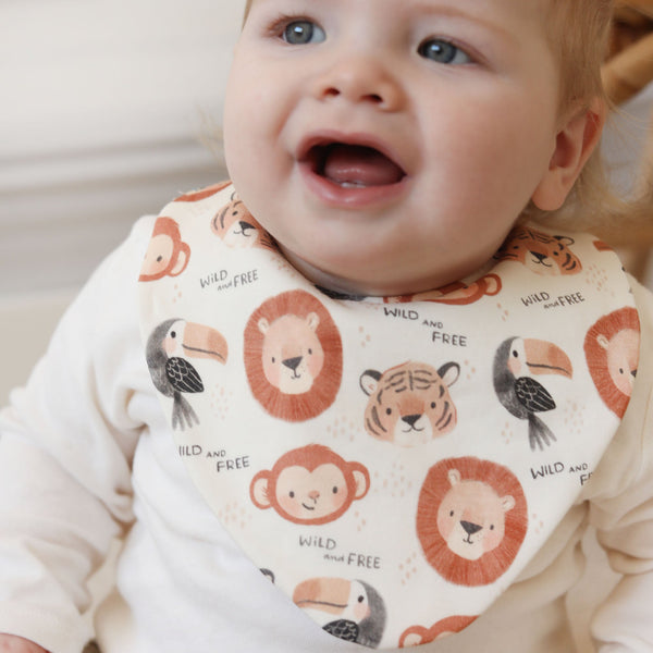Baby wearing a bib with animal prints and text
